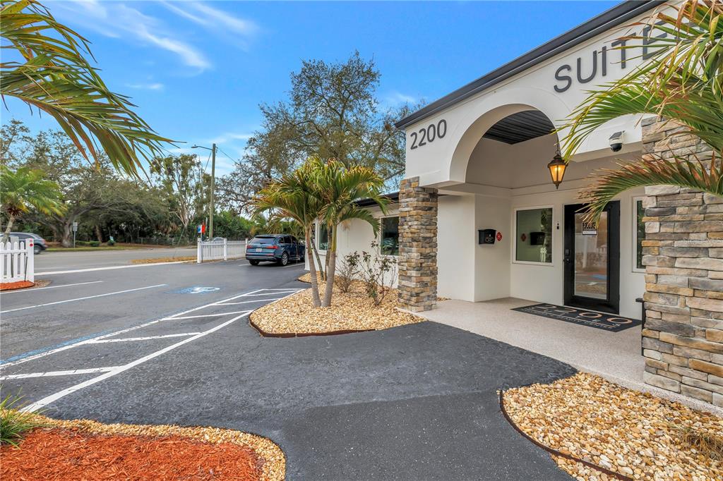 The exterior of a commercial building features a stone-accented entrance with a covered walkway — 2200 49TH STREET N, ST PETERSBURG, FL