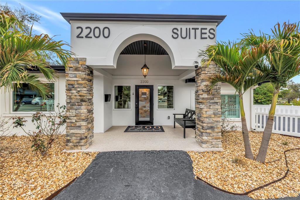 The exterior of a commercial building features a stone-pillared entrance with a covered walkway — 2200 49TH STREET N, ST PETERSBURG, FL