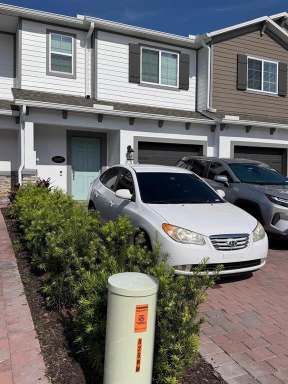 A row of two-story townhomes with paved driveways and parked cars in front — 5007 PRAIRIE PRESERVE RUN, ST CLOUD, FL