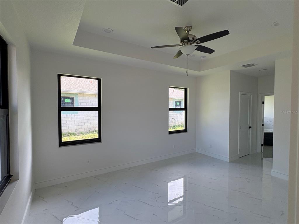 A kitchen island with pendant lighting overlooks an entryway with double doors and marble flooring — 2356 30TH AVENUE SW, VERO BEACH, FL