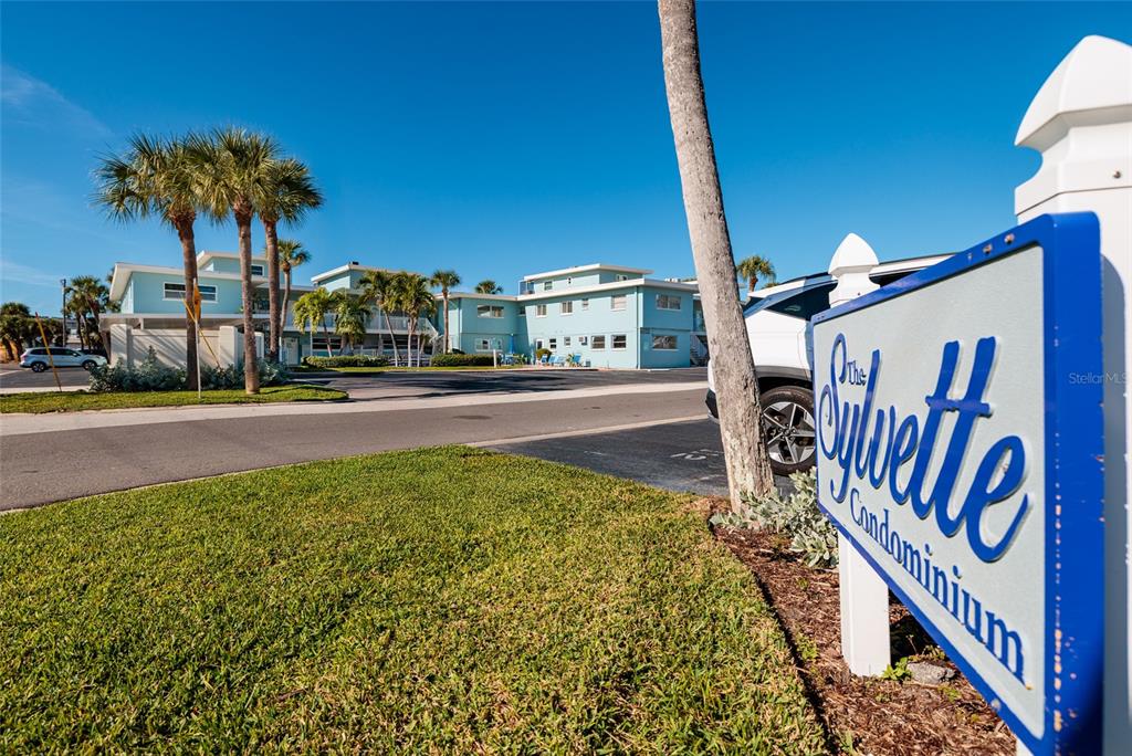 A sign for The Sylvette Condominium stands in front of a light blue apartment building — 6000 2ND STREET E UNIT 6, ST PETE BEACH, FL