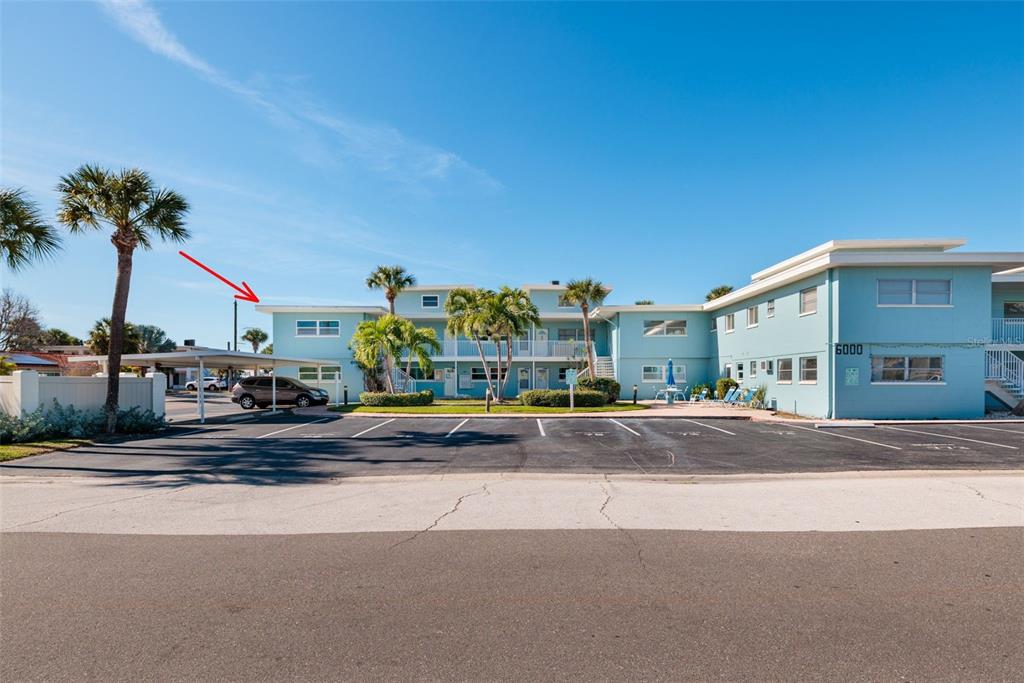 A light blue multi-story apartment building with a parking lot and palm trees — 6000 2ND STREET E UNIT 6, ST PETE BEACH, FL
