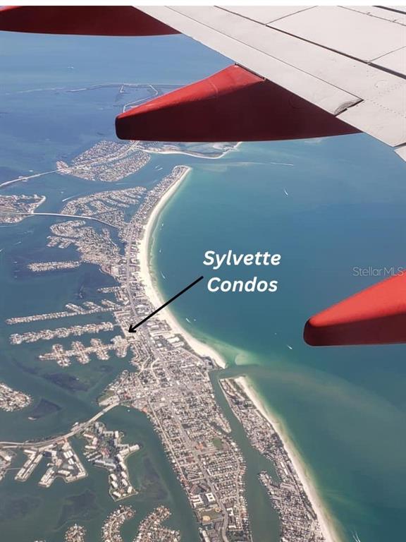 Aerial view of a coastal barrier island with an arrow pointing to the Sylvette Condos — 6000 2ND STREET E UNIT 6, ST PETE BEACH, FL