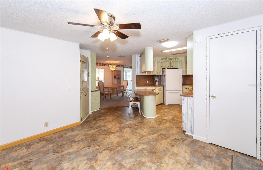 A kitchen with light green cabinets, a breakfast bar, and patterned vinyl flooring — 878 JOLANDA CIRCLE, VENICE, FL