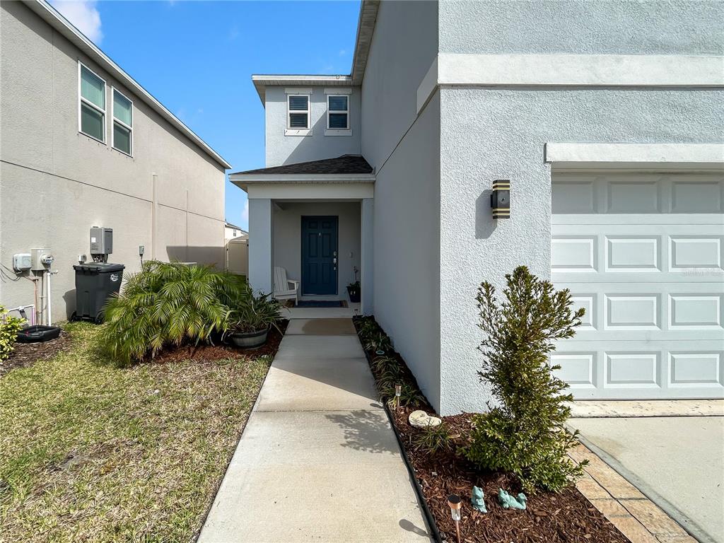 A concrete walkway leads to the front entrance of a two-story house with a garage — 6312 MILESTONE LOOP, PALMETTO, FL