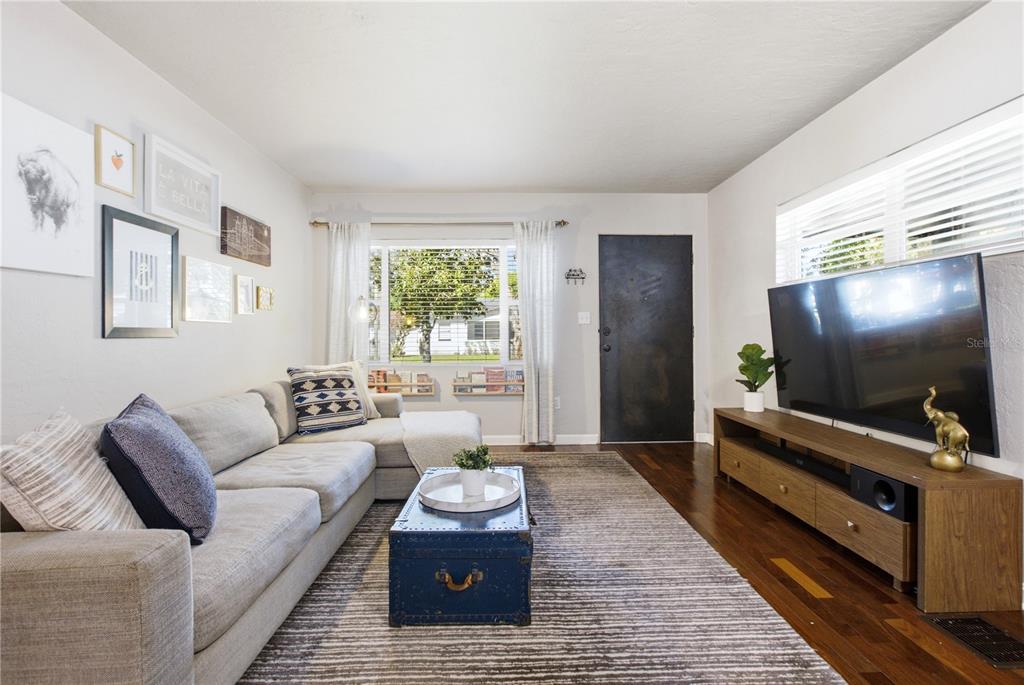 A living room features a gray sectional sofa, a blue trunk coffee table, and a television — 1017 N GLENWOOD AVENUE, ORLANDO, FL