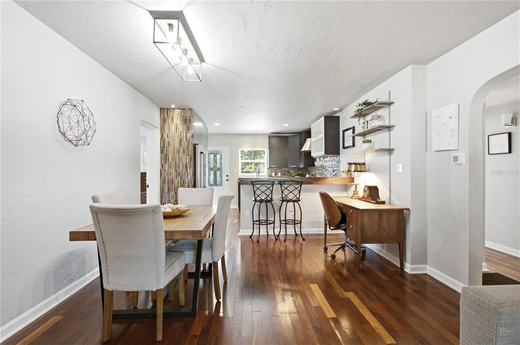 A dining area with a wooden table, chairs, and a desk adjacent to a kitchen — 1017 N GLENWOOD AVENUE, ORLANDO, FL