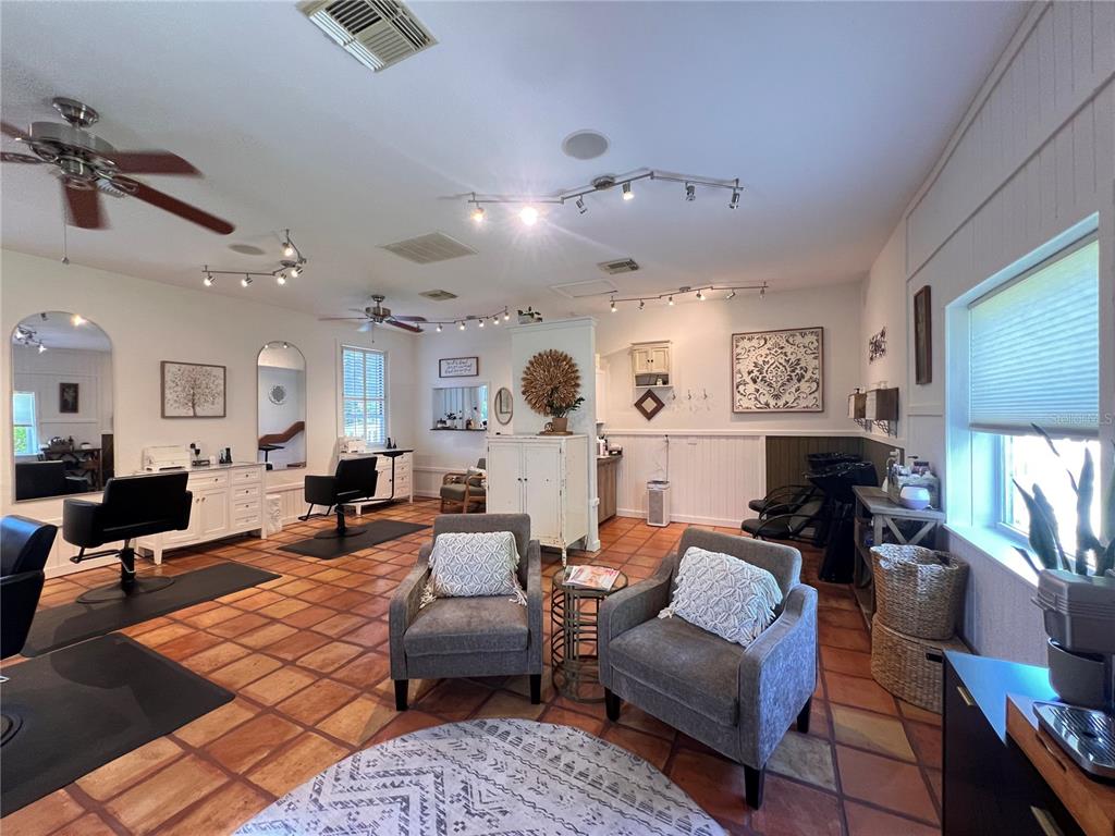 A hair salon features multiple styling stations, gray armchairs, and terracotta tile flooring — 180 RIO VILLA DRIVE, PUNTA GORDA, FL
