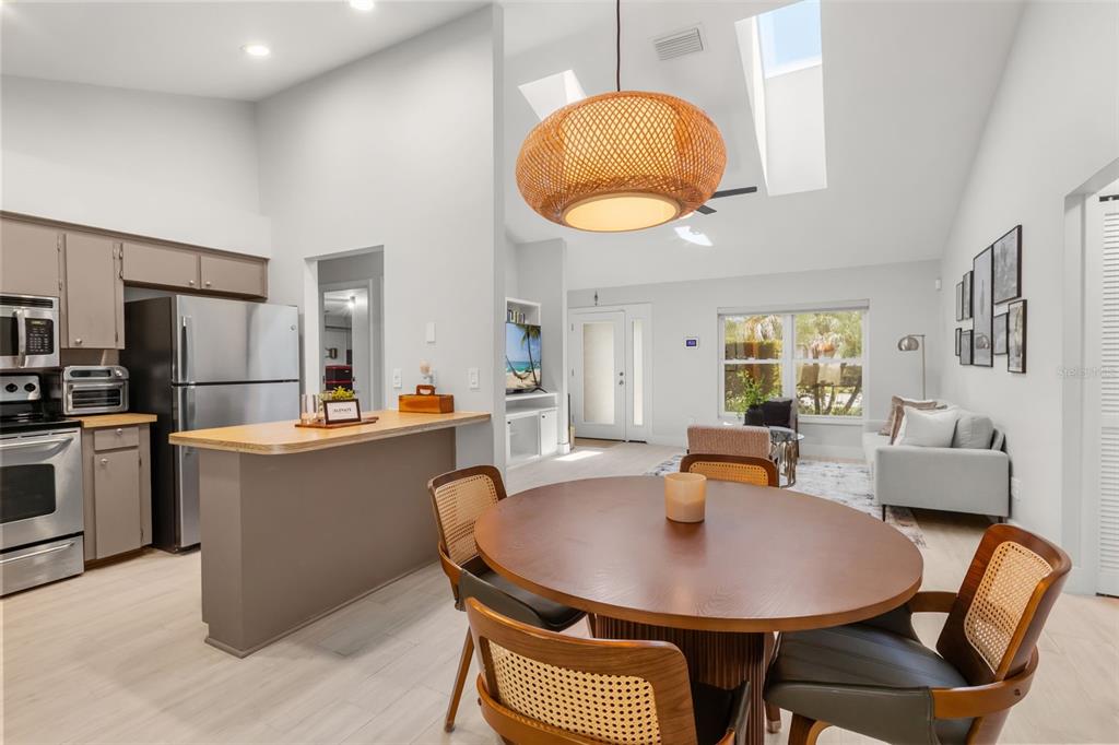 A kitchen with stainless steel appliances and a dining area with a round wooden table — 7384 GRAND AVENUE, WINTER PARK, FL