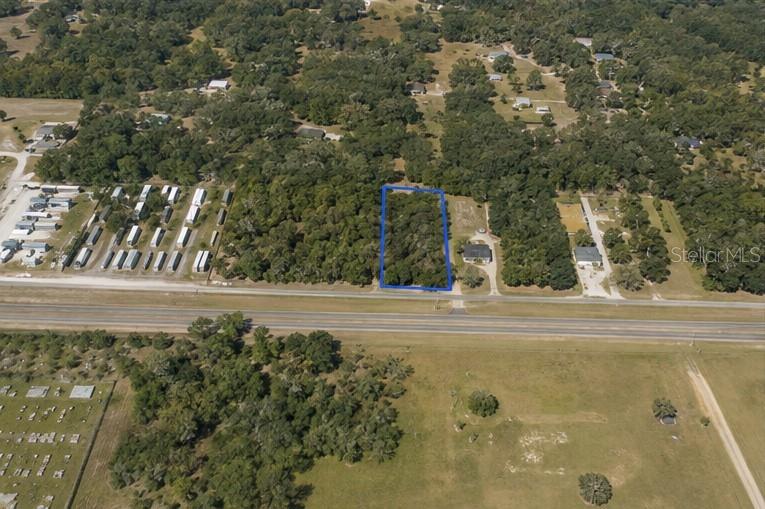 An aerial view shows a rectangular, wooded lot outlined in blue along a highway — CORTEZ BOULEVARD, BROOKSVILLE, FL