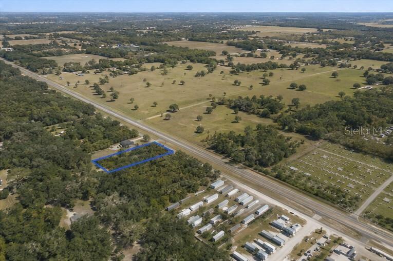 An aerial view shows a rectangular plot of land outlined in blue near a highway — CORTEZ BOULEVARD, BROOKSVILLE, FL