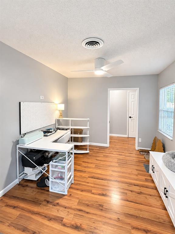 A living room with wood flooring, a large sectional sofa, and an adjacent dining area — 10626 BRESSLYN BOULEVARD, ORLANDO, FL