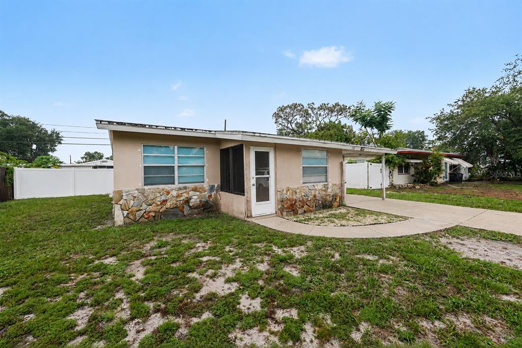 A single-story house with a stone facade, a white front door, and a concrete driveway — 131 EMERALD LANE, LARGO, FL
