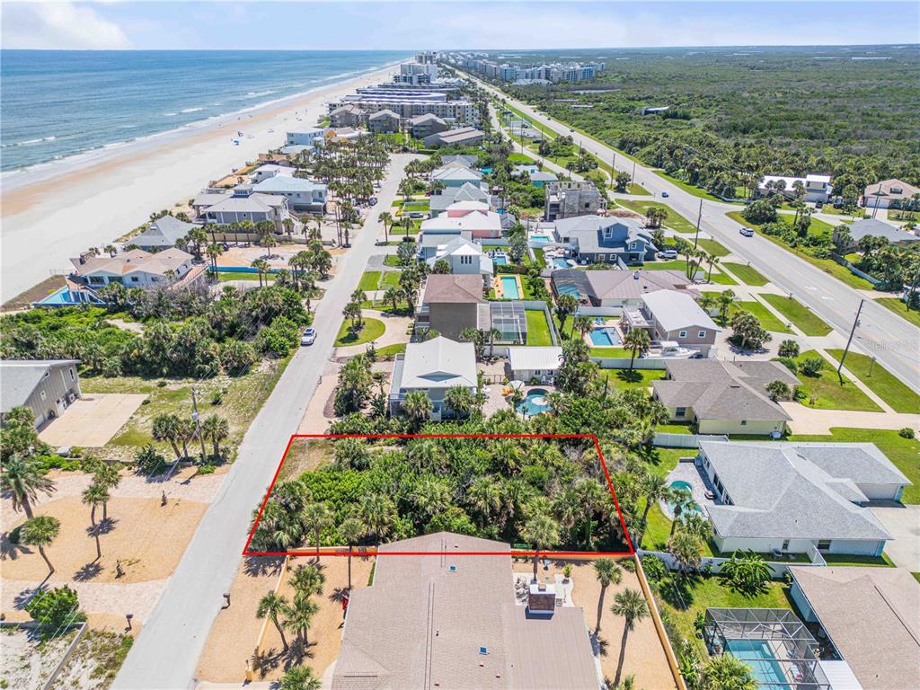 An aerial view shows a rectangular, undeveloped lot outlined in red near a beach — 4712 VAN KLEECK DRIVE, NEW SMYRNA BEACH, FL