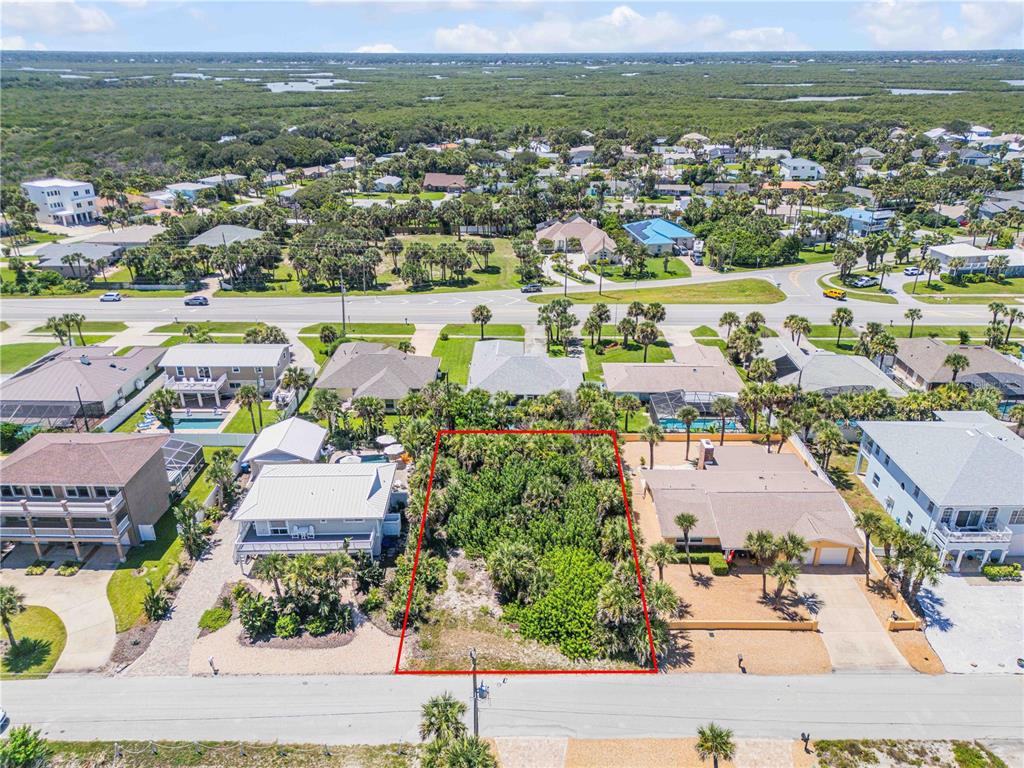 An aerial view shows a vacant, vegetation-covered rectangular lot situated between two residential houses — 4712 VAN KLEECK DRIVE, NEW SMYRNA BEACH, FL