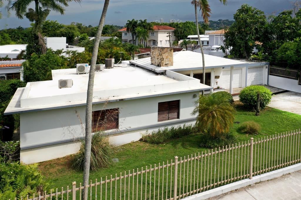 A white, single-story house with a flat roof, stone chimney, and a fenced front yard — . J STREET UNIT 3, GUAYNABO, PR