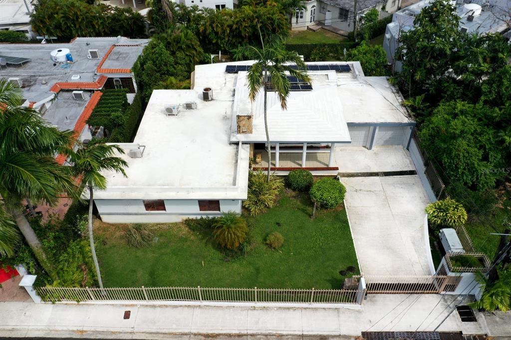 An aerial view shows a single-story house with a flat roof, solar panels, and driveway — . J STREET UNIT 3, GUAYNABO, PR