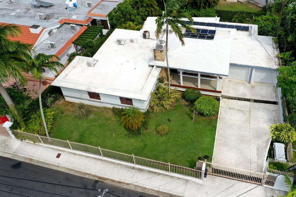 An aerial view shows a single-story house with a white roof, solar panels, and driveway — . J STREET UNIT 3, GUAYNABO, PR