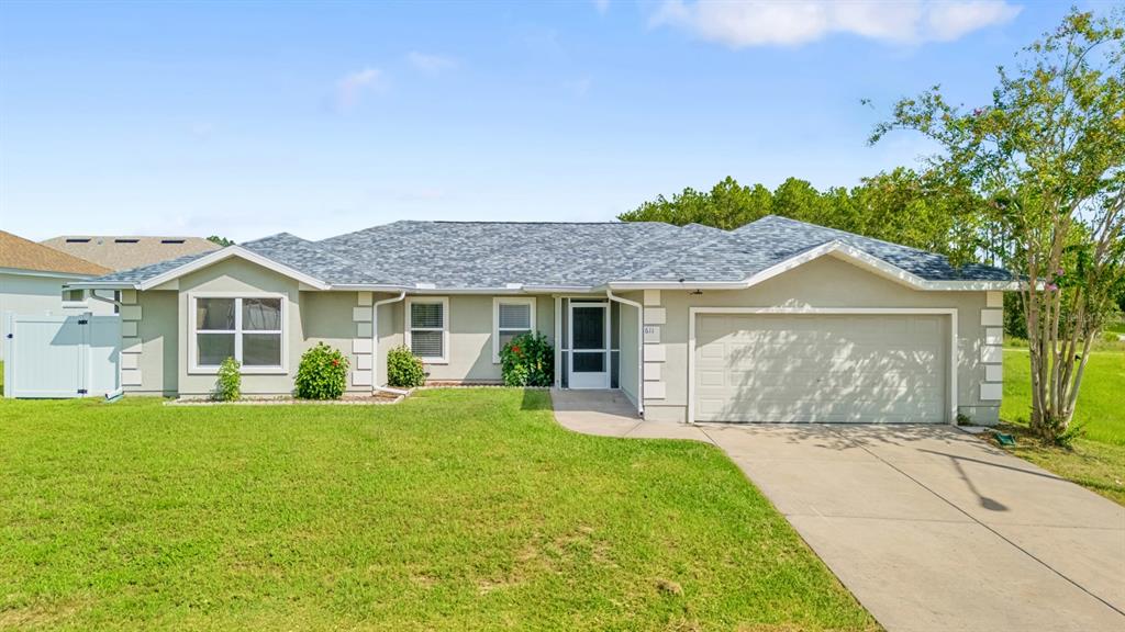 A single-story suburban house features a gray shingled roof, stucco exterior, and a two-car garage — 611 W WALKERTOWN DRIVE, CITRUS SPRINGS, FL