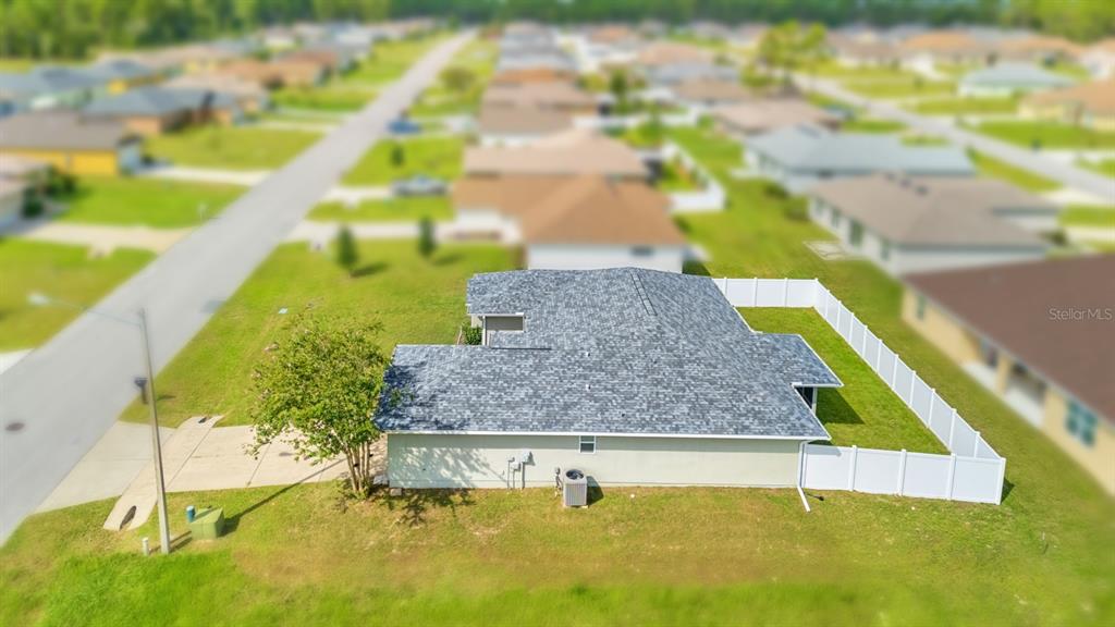 An aerial view shows a single-story house with a gray roof and a white fence — 611 W WALKERTOWN DRIVE, CITRUS SPRINGS, FL