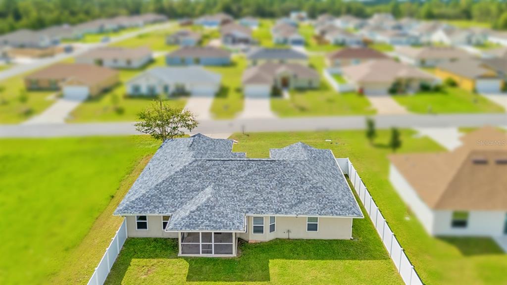 An aerial view shows the back of a single-story house with a screened-in porch — 611 W WALKERTOWN DRIVE, CITRUS SPRINGS, FL