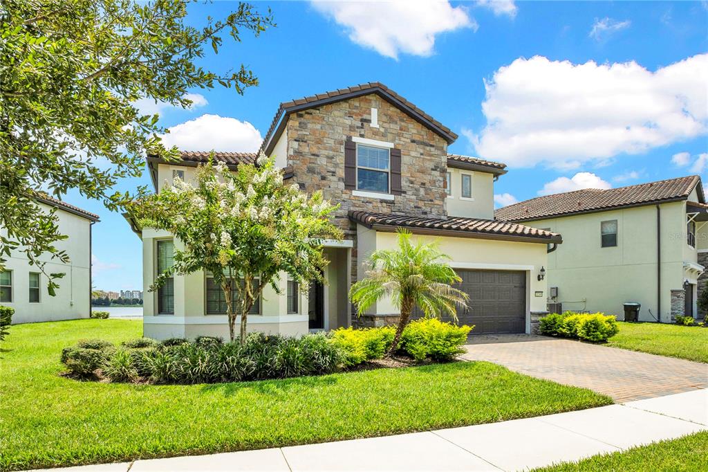 A two-story house with a stone facade, a two-car garage, and a landscaped front yard — 11340 LEMON LAKE BOULEVARD, ORLANDO, FL