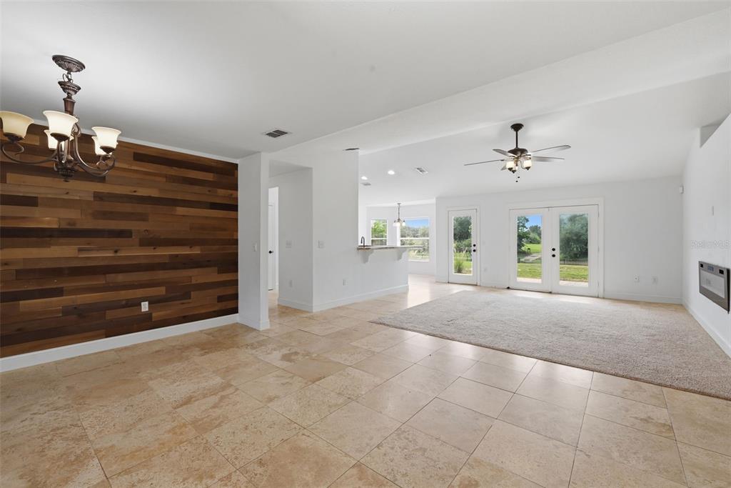 A living room features tile flooring, a wood-paneled accent wall, and double glass doors — 1845 FARRINGTON DRIVE, LAKELAND, FL