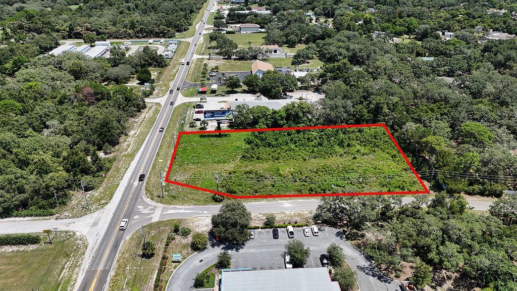 An aerial view shows a vacant, rectangular lot outlined in red next to a road — 18888 ACKSON STREET, SPRING HILL, FL
