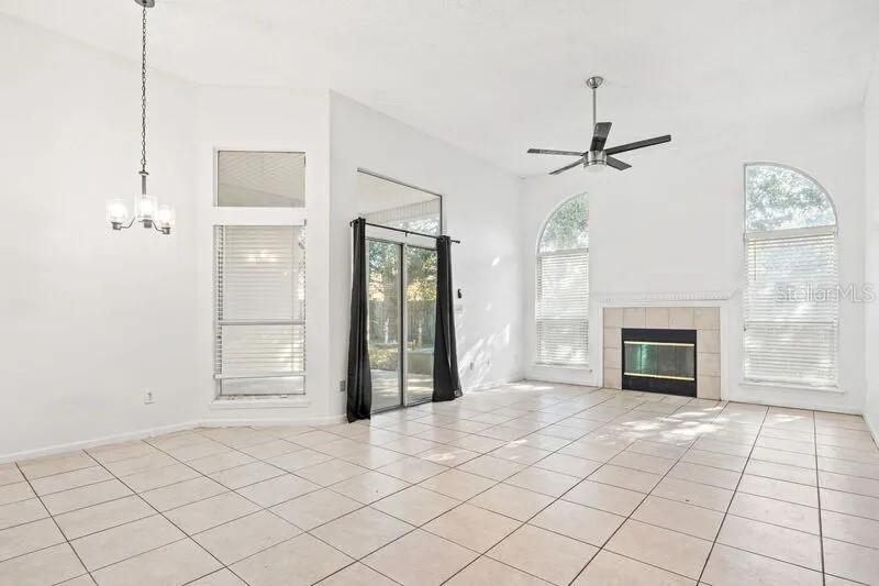 A bright living room features white tile floors, a fireplace, and large arched windows — 2429 W CEDAR TRACE DRIVE, JACKSONVILLE, FL