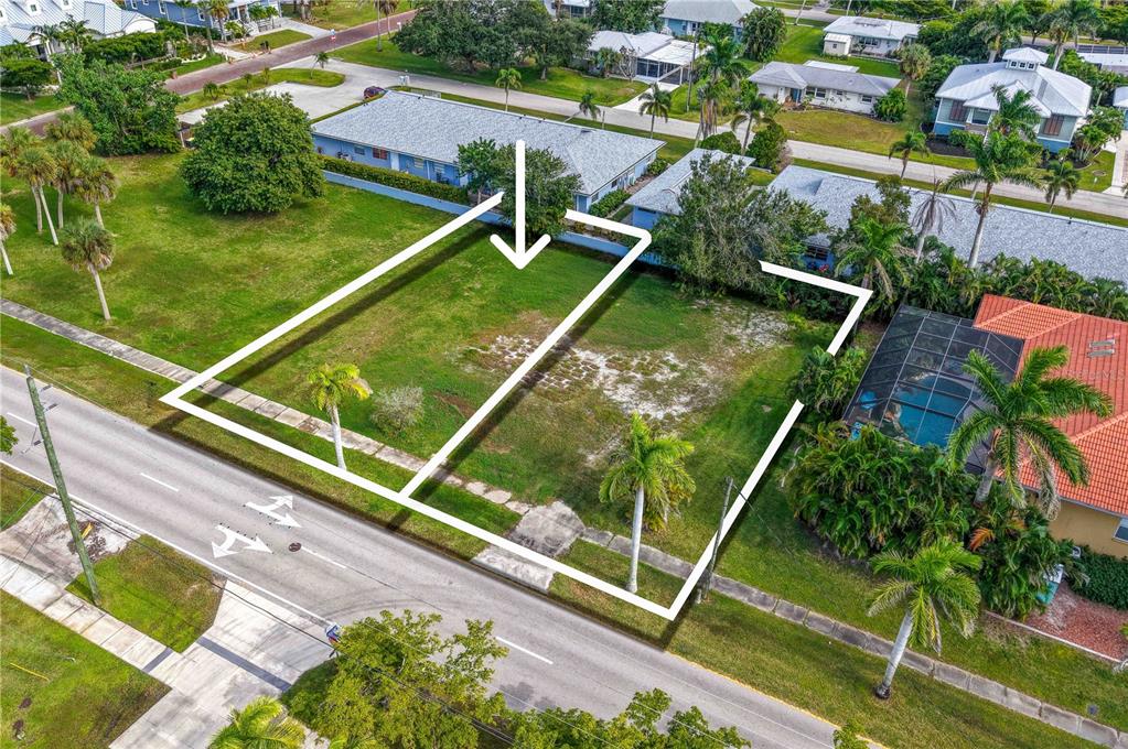 An aerial view shows two adjacent vacant residential lots bordered by a road and houses — 817 W MARION AVENUE, PUNTA GORDA, FL