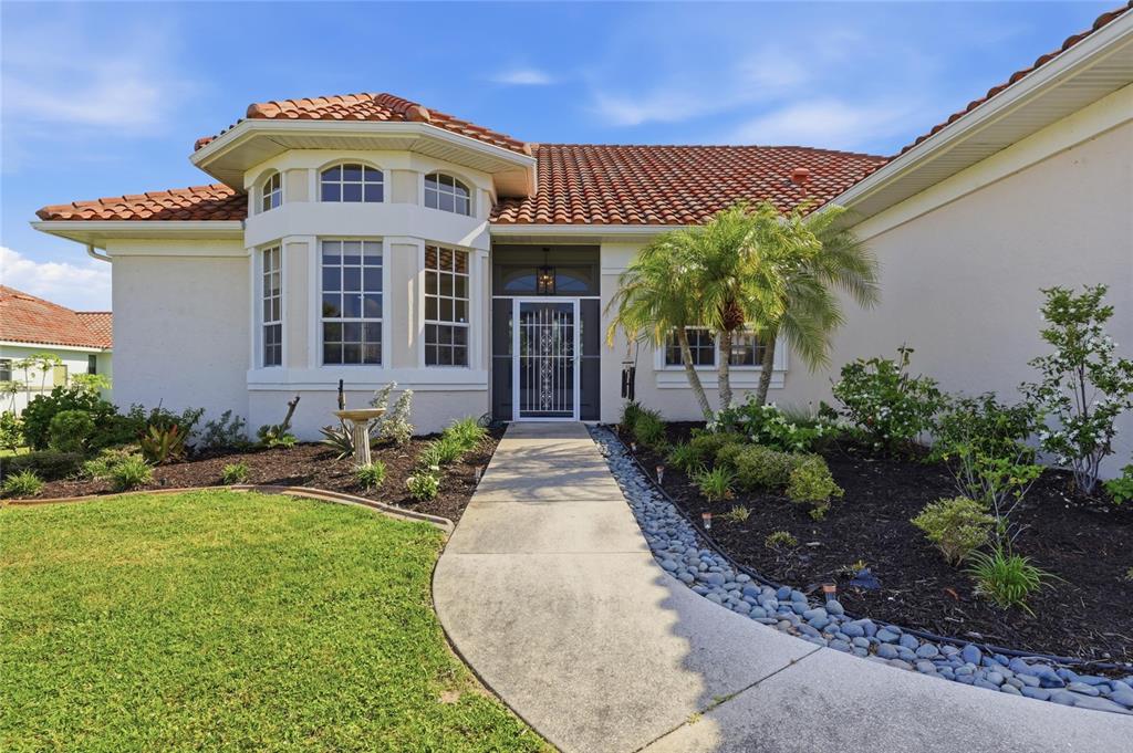 A single-story house with a tiled roof, a curved walkway, and a front entrance door — 4658 ARLINGTON DRIVE, PLACIDA, FL
