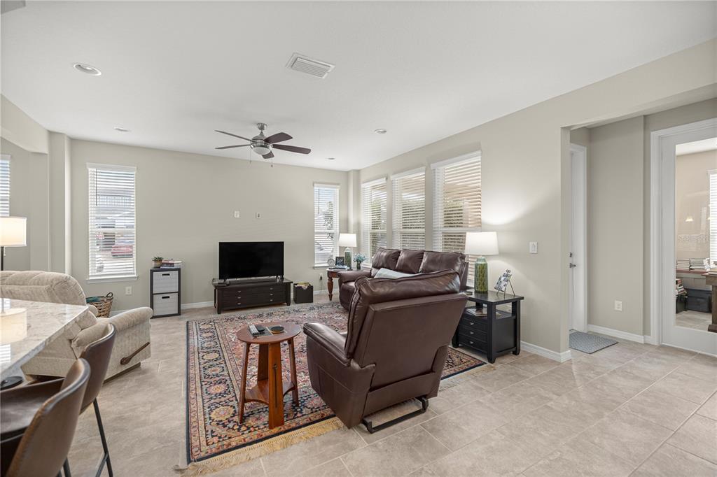 A living room features a brown leather sofa, a recliner, and a patterned area rug — 5504 NW 40TH LOOP, OCALA, FL