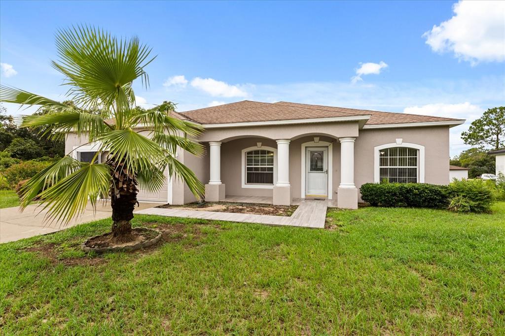 A single-story house with a palm tree in the front yard and a covered porch — 3544 SW 157TH LOOP, OCALA, FL
