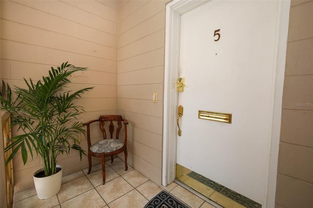 A white door labeled number five sits next to a potted plant and wooden chair — 311 E MORSE BOULEVARD UNIT 4-5, WINTER PARK, FL
