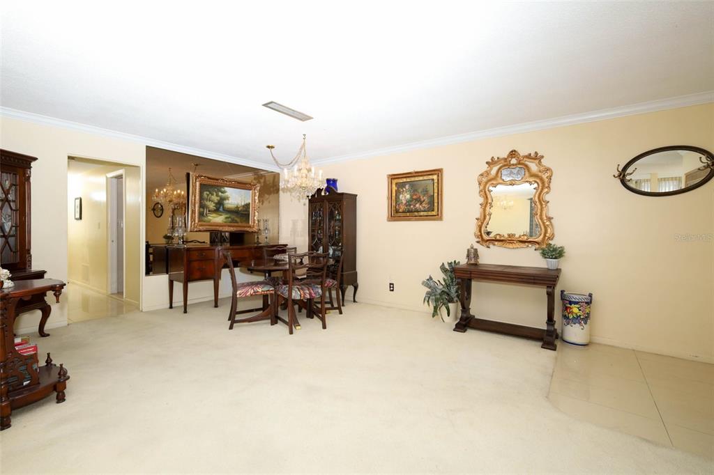 A dining area with a mirrored wall, chandelier, and traditional furniture on beige carpet — 311 E MORSE BOULEVARD UNIT 4-5, WINTER PARK, FL