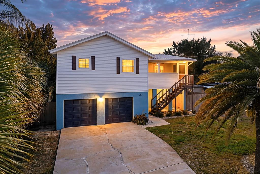 A two-story house with white siding, a blue lower level, and an exterior staircase — 287 BOULEVARD DES PINS, ST AUGUSTINE, FL
