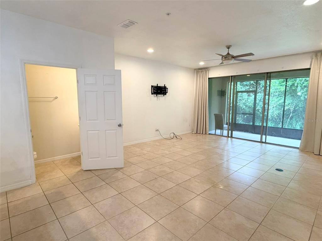 A living room with tile flooring, a ceiling fan, and sliding glass doors to a patio — 1288 PAVIA DRIVE, APOPKA, FL