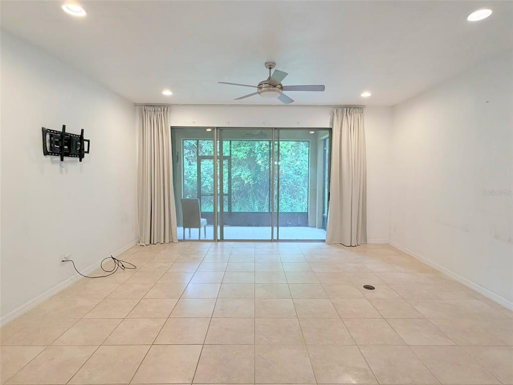 An empty room with tile flooring, a ceiling fan, and sliding glass doors to a patio — 1288 PAVIA DRIVE, APOPKA, FL
