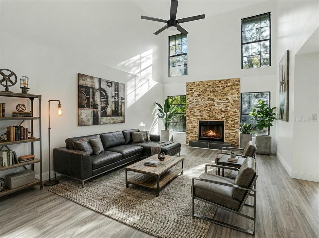 A living room features a stone fireplace, vaulted ceilings, a sectional sofa, and wood flooring — 1196 INDIAN BLUFF, APOPKA, FL
