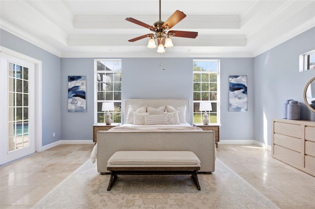 A bedroom with light blue walls, a tray ceiling, a ceiling fan, and a bed — 6533 CARTMEL LANE, WINDERMERE, FL