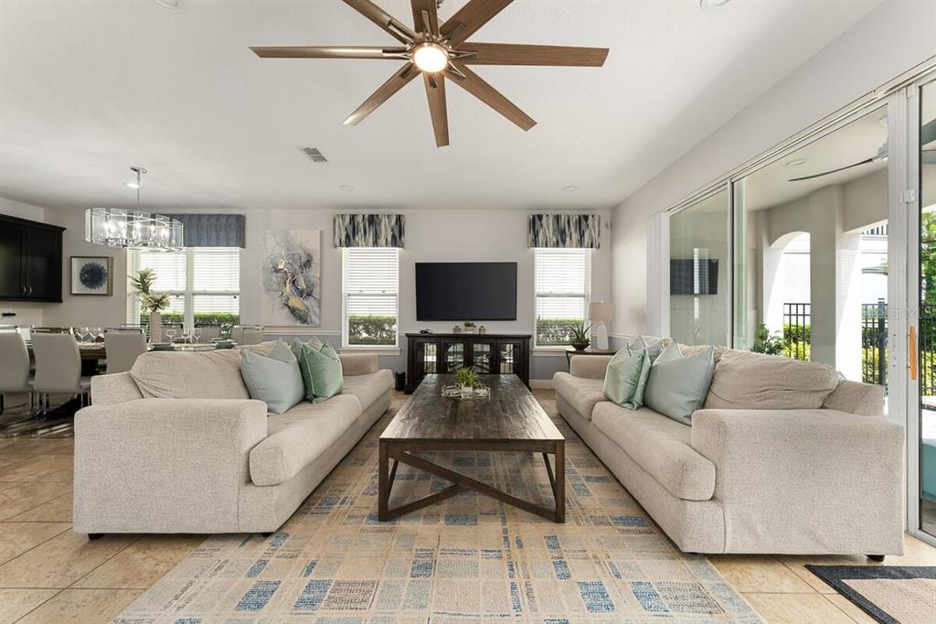 A living room features two beige sofas, a wooden coffee table, and a ceiling fan — 795 GOLDEN BEAR DRIVE, REUNION, FL