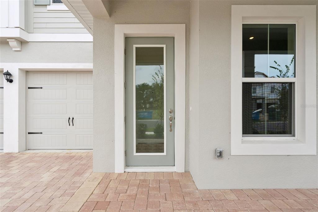 A modern kitchen features white cabinetry, a marble-topped island, stainless steel appliances, and hexagon backsplash — 17422 HONEYBELL TANGELO COURT, WINTER GARDEN, FL