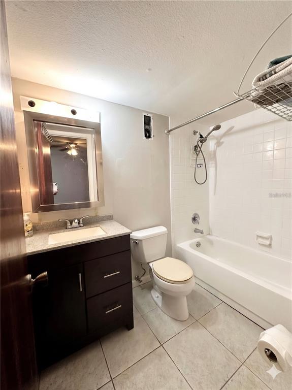 A bathroom features a dark vanity, a toilet, and a shower-tub combination with white tiles — 912 LAKE DESTINY ROAD UNIT F, ALTAMONTE SPRINGS, FL