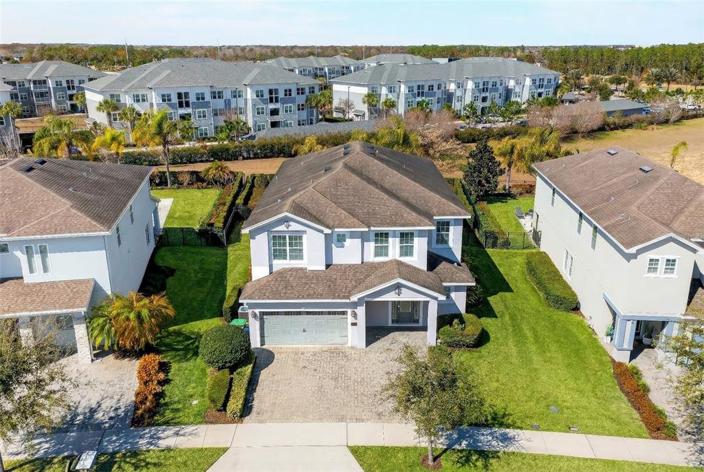 A two-story house with a paved driveway, a two-car garage, and a covered front entrance — 7724 FAIRFAX DRIVE, KISSIMMEE, FL