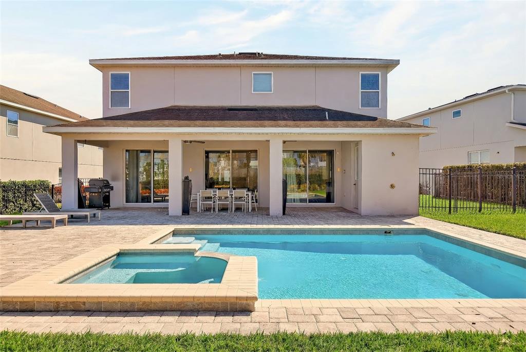 A modern kitchen features white cabinetry, stainless steel appliances, and a large island with seating — 7724 FAIRFAX DRIVE, KISSIMMEE, FL