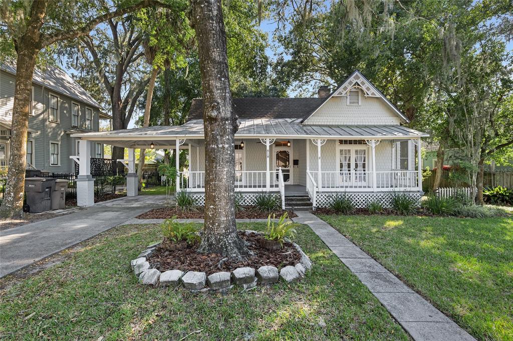 A single-story house with a metal roof, a front porch, and a carport — 818 SE 3RD STREET, OCALA, FL