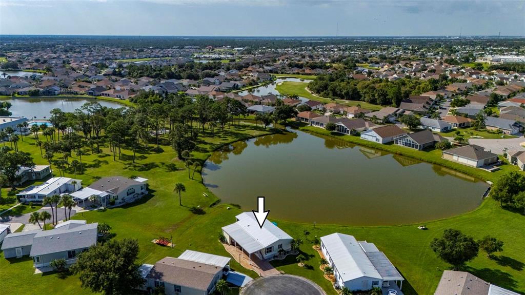 An aerial view shows a residential house with a white roof situated beside a lake — 1000 KINGS HIGHWAY UNIT 262, PORT CHARLOTTE, FL