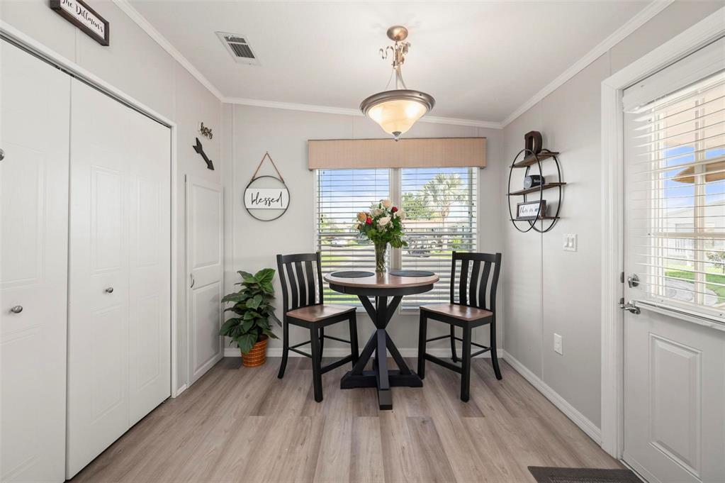 A dining area with a small round table, two chairs, light flooring, and a window — 1000 KINGS HIGHWAY UNIT 262, PORT CHARLOTTE, FL