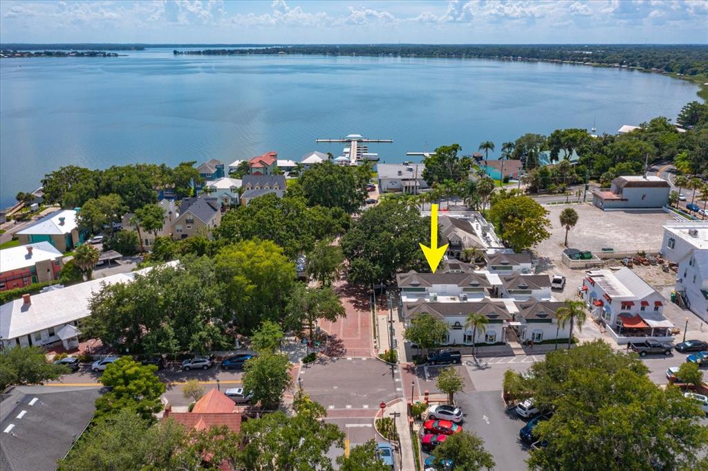 An aerial view shows a multi-story building with a yellow arrow pointing toward its roof — 237 W 4TH AVENUE UNIT 2, MOUNT DORA, FL