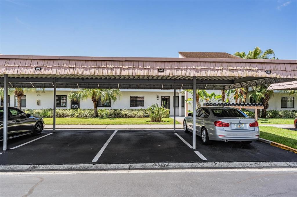 A covered parking area with three numbered spaces in front of a residential building — 107 LAKEVIEW PLACE UNIT 7, OLDSMAR, FL